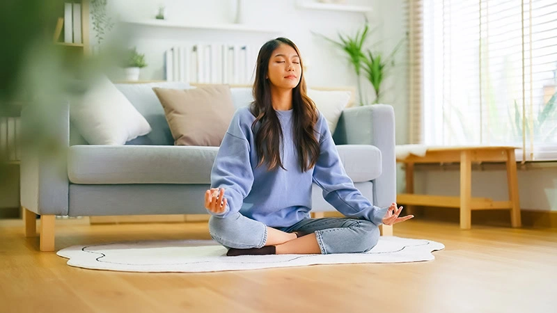 A woman practices meditation for anxiety in recovery.